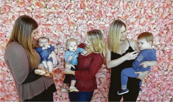  ?? Photos by Melissa Phillip / Staff photograph­er ?? Meredith Arthur, from left, with Julie, 12 weeks; Brittni Maetzold with Charlotte, 1; and Erin Clayton with Parker, 1, take advantage of the Flower Vault scenery.