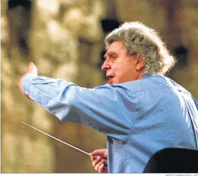  ?? ORESTIS PANAGIOTOU / EFE ?? Mikis Theodoraki­s dirigiendo a su orquesta a los pies de la Acrópolis de Atenas en 2001.