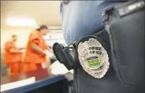  ??  ?? GUARD WATCHES detainees fold clothes at the recently opened Mesa Verde Detention Center in Bakersfiel­d.