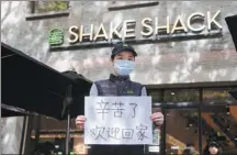  ?? PROVIDED TO CHINA DAILY ?? A Shanghai restaurant worker holds a piece of paper that reads: “Welcome home. Thank you for your hard work.”