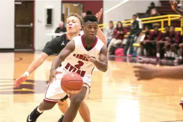  ?? Staff photo by Kayleigh Moreland ?? Liberty-Eylau junior varsity player Takylan Hampton dribbles past Hope varsity players during the opening round of the Gunslinger Tournament on Thursday at Lion Gym in New Boston, Texas. Hope won, 52-34.