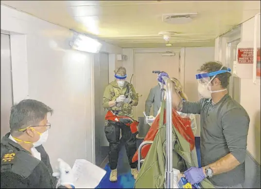  ?? The Associated Press ?? Medical personnel with the 129th Rescue Wing of the California Air National Guard don protective equipment after delivering coronaviru­s testing kits Thursday to the Grand Princess cruise ship off the coast of California.