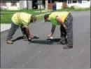  ?? SUBMITTED PHOTO ?? Valley Township Streets Department employees Brian Myers and Josh Waltrop cover up racial graffiti on Wednesday that was painted on West 10th Avenue in the township.