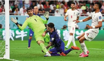  ?? — reuters ?? Pushing the limits: united States’ christian Pulisic (centre) colliding with Iran’s alireza beiranvand after he scored the first goal.