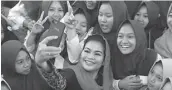  ?? TIM PEMENANGAN GUS IPUL-PUTI FOR JAWA POS ?? DUA KOTA: Khofifah melayani pembeli di Pasar Wonokromo, Surabaya. Foto kanan, Puti bersama santriwati di Bondowoso.