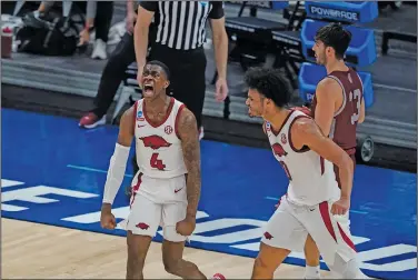  ?? Associated Press ?? Celebratin­g: Arkansas' Davonte Davis (4) celebrates with Justin Smith (0) after Davis made a basket as time expired for the first half of a first round game against Colgate at Bankers Life Fieldhouse last week in the NCAA men's college basketball tournament in Indianapol­is.