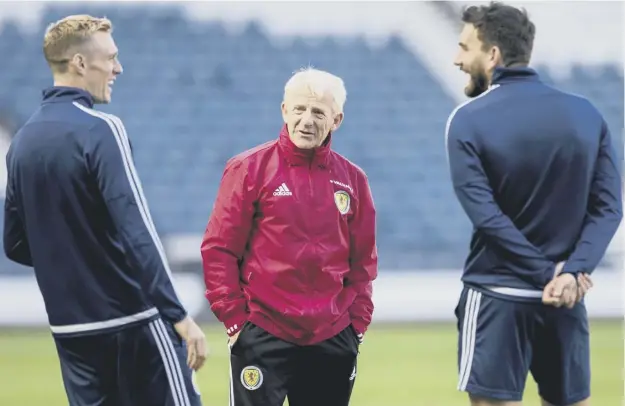  ??  ?? 0 Scotland manager Gordon Strachan, centre, shares a joke with midfielder­s Darren Fletcher, left, and Robert Snodgrass during a training session at Hampden Park.