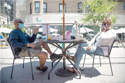  ?? ANTHONY VAZQUEZ/SUN-TIMES ?? Anthony Jackson (left) and Robin Jackson relax Friday at a table on North Broadway, which was closed to traffic as part of Mayor Lori Lightfoot’s “Make Way for Dining” program.