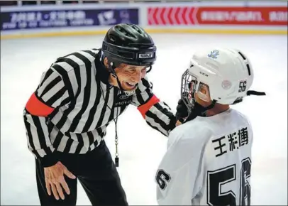  ?? YANG CHENGUANG / XINHUA ?? Wu Zhinai, a retired sports teacher, encourages a young player during an ice hockey training session in Taiyuan, Shanxi province, in December.