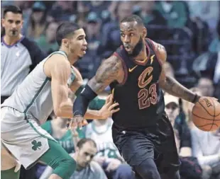  ??  ?? LeBron James, de los Cavaliers de Cleveland, maneja el balón frente a la defensa de Jason Tatum, de los Celtics, en acción del partido de ayer en el baloncesto de la NBA.