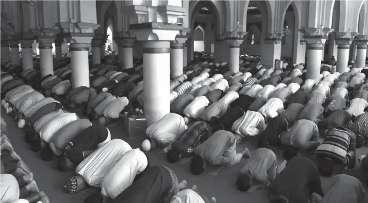  ?? REUTERS ?? A MONTH OF FASTING AND PRAYERS. Filipino Muslims pray inside the Golden Mosque in Manila on Friday, a day before the beginning of the Muslim holy month of Ramadan. Ramadan, which is the 9th month of the Islamic calendar, is observed with prayer and...