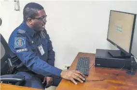  ?? (Photos: Anthony Lewis) ?? Officer assigned to the statistics unit with responsibi­lity for configurin­g of systems Detective Inspector Donavon Henderson utilising a report-taking platform.