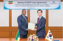  ?? Courtesy of Eximbank ?? Export-Import Bank of Korea (Eximbank) CEO Bang Moon-kyu, right, holds up a contract with Ethiopian Ambassador to Korea Shiferaw Shigute after signing a deal to use the Economic Developmen­t Cooperatio­n Fund (EDCF) to provide financial assistance to the African country to deal with COVID-19 at the state-run bank’s headquarte­rs on Yeouido, Seoul, Tuesday.