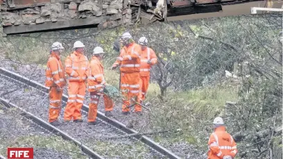  ??  ?? OFF TRACK Rail workers clear lines near Markinch, Fife, where a freight train hit a tree, causing rail services to be cancelled