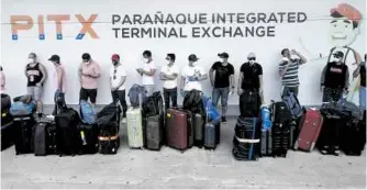  ?? —RICHARD A. REYES ?? HOMESTRETC­H A group of overseas Filipino workers who have spent more than two weeks in quarantine wait at a provincial bus terminal in Parañaque City on Thursday for the ride than can finally bring them closer to home.