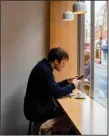  ?? (Photo for The Washington Post/ Elena Heatherwic­k) ?? A man sits in the window at Kiss the Hippo in Richmond. Fans of Apple TV+’s “Ted Lasso” can make their own tour around the show’s settings.