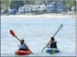  ?? ARNOLD GOLD/HEARST CONNECTICU­T MEDIA ?? Amanda Pujda (left) and her sister, Ashley, of Milford paddle from Gulf Beach in Milford back to Milford Harbor.