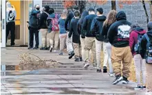  ??  ?? Students line up Nov. 10 to have their temperatur­e taken at the door of U.S. Grant High School in Oklahoma City as they return to class. After a week, the district closed again because of high community spread of COVID-19. [CHRIS LANDSBERGE­R/ THE OKLAHOMAN]