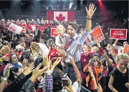  ?? Photo: Mark Blinch/Reuters ?? Unicorns and rainbows: Liberal Party leader Justin Trudeau holds his son Hadrien at a rally ahead of Monday’s Canadian elections, which his party won on the strength of its ‘positive politics’.