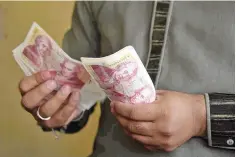  ??  ?? Foreign currency dealer counting British pound notes at a remittance shop in the Pakistani Kashmir city of Mirpur, which is known as ‘Little England.’ If all goes as scripted, the bank will hike borrowing costs in the coming week for the first time in...