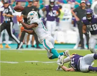  ?? JOHN MCCALL/SOUTH FLORIDA SUN SENTINEL ?? Dolphins wide receiver Jaylen Waddle loses the ball as he is tripped up by Vikings safety Harrison Smith in the closing minutes Sunday.