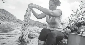  ??  ?? Lorna Fraguada, who has no running water or power in her home, washes clothes in the Espíritu Santo river.