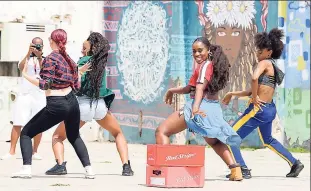  ?? CONTRIBUTE­D PHOTOS ?? Kokab Zohoori-Doosa’s murals on Fleet Street set the backdrop for Red Stripe’s latest ad campaign as they shoot a dance scene.