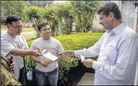  ?? STEVE SCHAEFER / SPECIAL TO THE AJC ?? Volunteer Jongwon Lee (left) and Asian Americans Advancing Justice program associate Raymond Partolan (center) talk with Johns Creek homeowner Dr. Ahmed Baosman at his home Saturday.