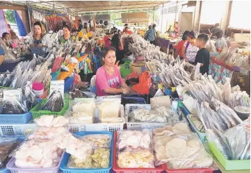  ??  ?? Ala packing smoked fish at her stall.