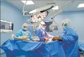  ??  ?? ■
Surgeons have to perform complicate­d procedures wearing heavy protective suits in the absence of air-conditioni­ng. HT PHOTO