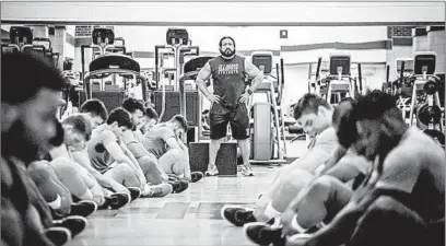  ??  ?? Illinois strength and conditioni­ng coach Lou Hernandez guides Illini players through a workout March 7 in Champaign.