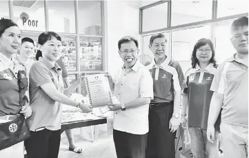  ??  ?? Dr Sim (third left) hands over a certificat­e of appreciati­on to a stall operator. Also seen are Dr Yao (third right) and Yeo (left).