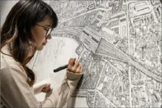  ?? Ng Han Guan/Associated Press ?? Chinese artist Yang Qian uses dots to re-create an aerial view of Wuhan, China, at her studio in the central Chinese city where the coronaviru­s was first identified.