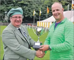  ?? 16_t34_ObanGames2­3 ?? Rob Adair from Canada was on holiday and left with a trophy after he won the sheaf tossing competitio­n. Matthew Anderson, steward, presented him with the trophy.