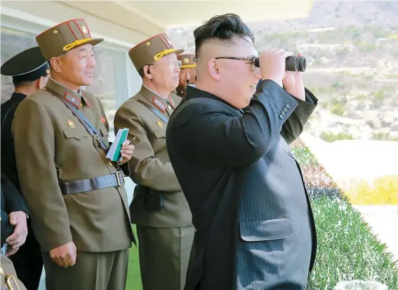  ??  ?? Sur cette photo non datée, on voit le chef nord-coréen Kim Jong-Un assister à une démonstrat­ion de force de son armée.