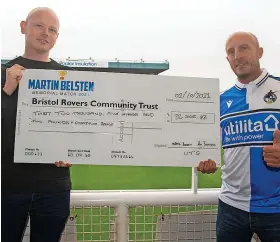  ?? ?? Ash Belsten, left, passes over a cheque for £32,502.42 to Adam Tutton, chief executive of the Bristol Rovers Community Trust, following the recent fundraisin­g match in memory of his grandfathe­r