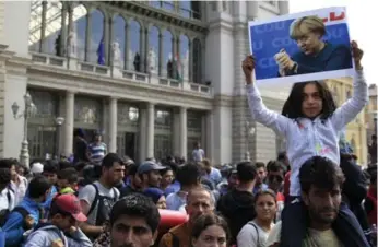  ?? BERNADETT SZABO/REUTERS FILE PHOTO ?? Angela Merkel, seen on a poster held by a migrant girl, called for European “solidarity” in dealing with the crisis.