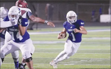  ?? (Special to NWA Democrat-Gazette/Brent Soule) ?? Rogers’ Christian Francisco (1) scrambles out of the pocket against the Springdale Bulldogs on Friday at Whitey Smith Stadium in
Rogers.