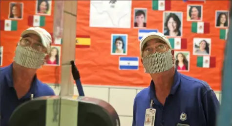  ?? LM Otero/Associated Press ?? Charles DeLong, a Richardson Independen­t School District facility services worker, watches the installati­on of a Plexiglass barrier in the student’s restroom Wednesday at Bukhair Elementary School in Dallas.