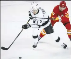  ?? Associated Press ?? Kings defenseman Andreas Englund (5) is checked by Calgary Flames forward Yegor Sharangovi­ch (17) during the second period, Tuesday, in Calgary, Alberta.