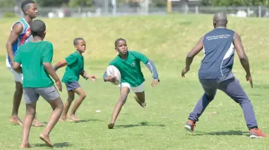  ?? PICTURES: HENK KRUGER ?? RUGBY FEVER: Under 13 player Qhama Thafeni of Khayelitsh­a runs with the ball during a Connect Rugby Training session at the Green Point Urban Park.