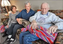  ?? Dan Watson/ The Signal ?? (Above) 104-yearold David Gilbert, right, opens a birthday gift as daughter Marty Williams, left, and son Jay Gilbert celebrate his birthday at his home in Valencia on Saturday. (Left) Gilbert savors a piece of candy — which he says is the secret to longevity — as he celebrates his 104th birthday.