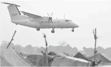  ??  ?? A United Nations World Food Programme (WFP) plane lands near makeshift shelters housing internally displaced people (IDPs) at the M’Poko internatio­nal airport in Bangui, Central African Republic on Saturday. — Reuters photo