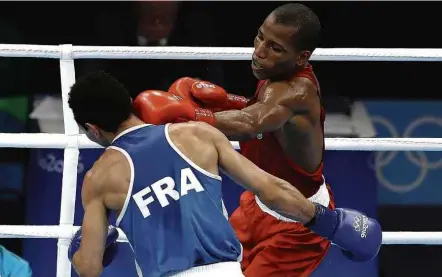  ?? Flávio Tavares - 16.ago.2016/Jornal “Hoje em Dia”/Folhapress ?? O brasileiro Robson Conceição golpeia o francês Sofiane Oumiha em final de boxe nos Jogos Olímpicos do Rio, em 2016 GINÁSTICA ARTÍSTICA