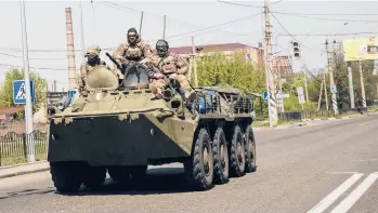  ?? LYNSEY ADDARIO/THE NEW YORK TIMES ?? Ukrainian fighters roll through Kramatorsk on Friday in Ukraine’s eastern Donbas region.