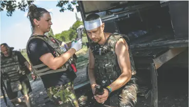  ?? ?? Hanna Khurava, a medic in the Ukrainian military, treats Dema, 37, a soldier lightly
wounded after Russian forces’ retaliator­y fire.