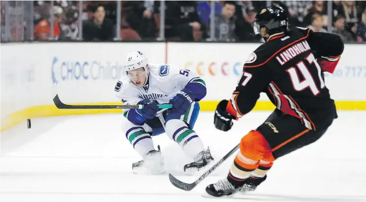  ?? — THE ASSOCIATED PRESS ?? Canucks defenceman Troy Stecher chips the puck past Ducks blue-liner Hampus Lindholm Sunday during Vancouver’s 2-1 victory in Anaheim.