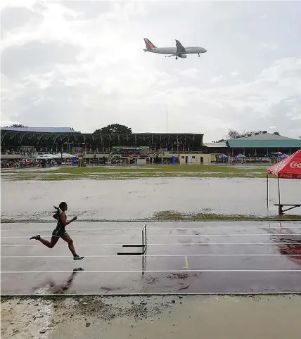  ?? JOYCE CAMPAÑA
KRISTINE ?? Straight to the finish line: A Philippine Airlines plane arrives in Tagbilaran City in Bohol as an athlete competes in the 400-meter hurdle in the ongoing Central Visayas Regional Athletic Associatio­n (CVIRAA) Meet.