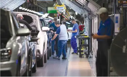  ?? STAFF FILE PHOTO BY ERIN O. SMITH ?? Volkswagen employees perform checks as vehicles move down the assembly line at the Volkswagen Assembly Plant in 2017 in Chattanoog­a. The labor department reported 157,000 jobs were added in July. The growth can be attributed to increased consumer spending creating more demand for workers in industries such as manufactur­ing.