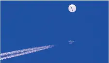  ?? ?? In this photo provided by Chad Fish, a large balloon drifts above the Atlantic Ocean Saturday, just off the coast of South Carolina with a fighter jet and its contrail seen below it. (Chad Fish via AP)